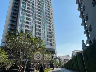 Modern high-rise building with lush greenery and clear blue sky