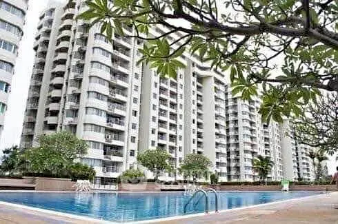 Luxurious high-rise apartments with a stunning poolside view and lush greenery.