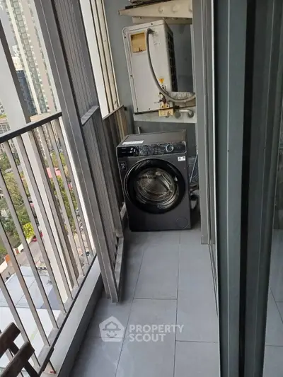 Compact balcony with washing machine and city view, ideal for urban living.