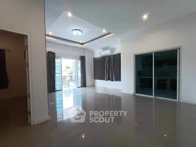 Spacious modern living room with glossy floors and large windows for natural light.