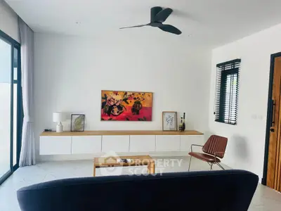 Modern living room with sleek furniture and artistic decor, featuring a large window for natural light.