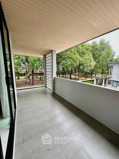 Spacious balcony with modern design overlooking lush greenery, perfect for relaxation and outdoor enjoyment.