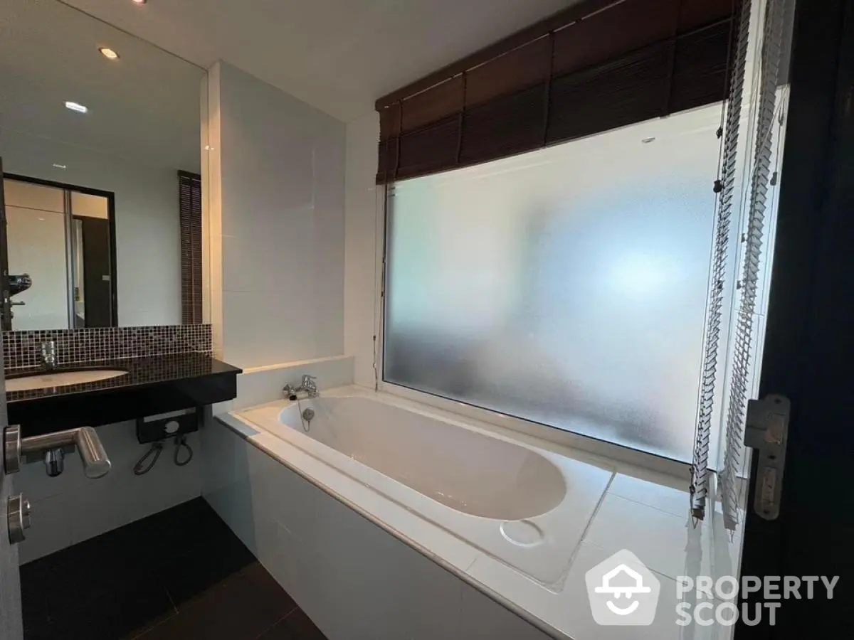 Modern bathroom with sleek design and large frosted window for privacy