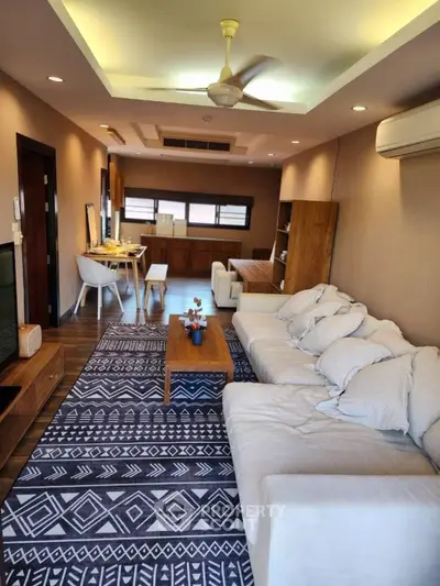 Spacious living room with modern decor and open dining area, perfect for entertaining.