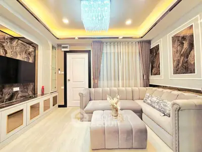Luxurious living room with elegant chandelier and plush sofa in modern apartment.