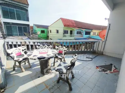 Charming balcony with unique cow-themed furniture and vibrant neighborhood view.