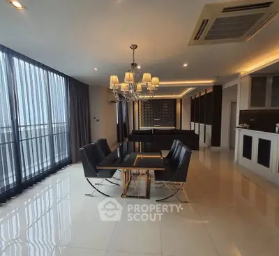 Luxurious dining area with elegant chandelier and modern open kitchen in a high-end apartment.