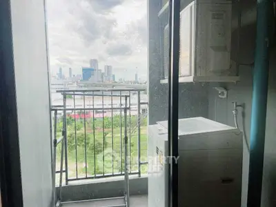 Compact balcony with washing machine and city view, ideal for urban living.