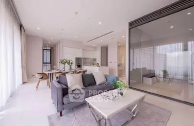 Luxurious open-plan living room with modern kitchen and elegant decor in a high-end apartment.