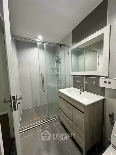 Modern bathroom with sleek shower and stylish vanity in contemporary apartment.