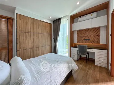 Modern bedroom with built-in wardrobe and study desk, featuring wooden accents and natural light.