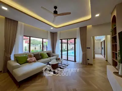 Luxurious living room with pool view, modern decor, and elegant lighting in a stylish home.