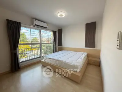 Bright and airy bedroom with large window and modern furnishings