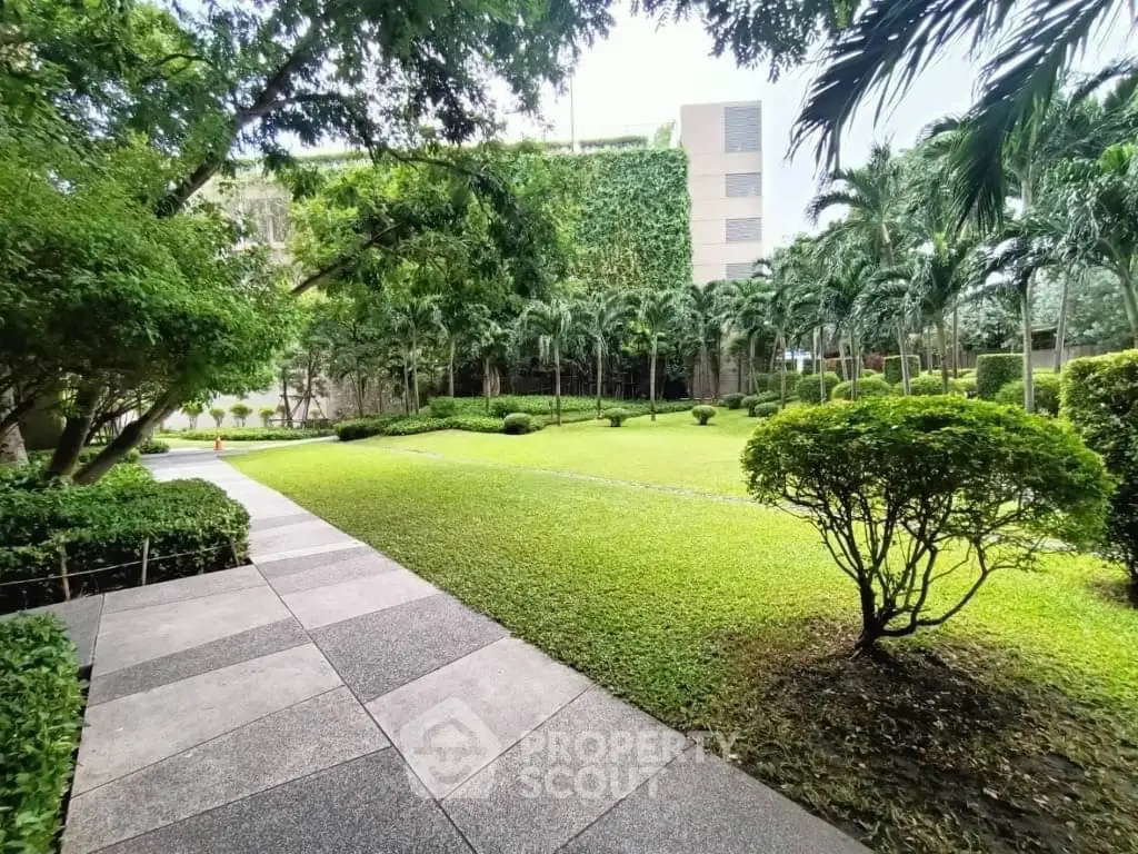Lush green garden with paved walkway in modern residential complex