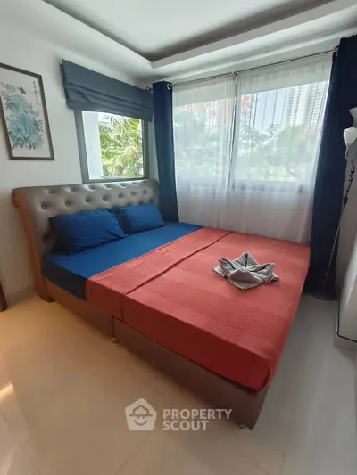 Cozy bedroom with large windows and stylish decor in a modern apartment.