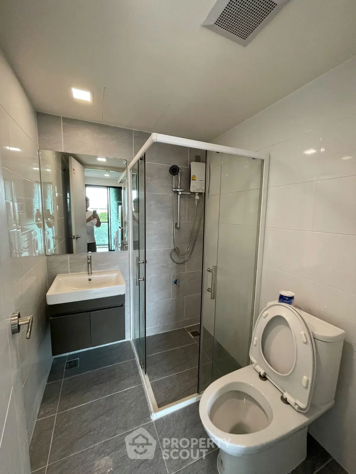 Modern bathroom with glass shower and sleek fixtures in contemporary home.