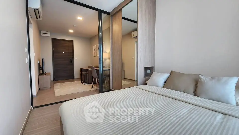 Modern bedroom with elegant decor and sliding glass doors leading to a cozy living area.