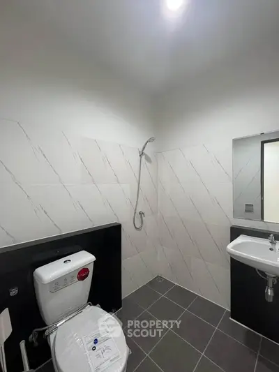 Modern bathroom with sleek tiles and minimalist fixtures, perfect for contemporary living.