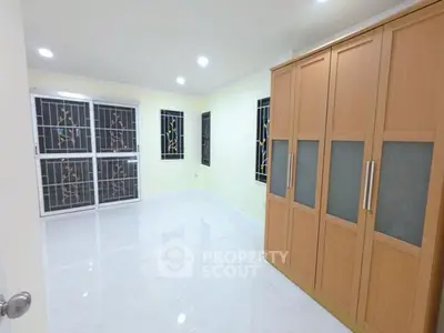 Spacious bedroom with large wardrobe and bright windows