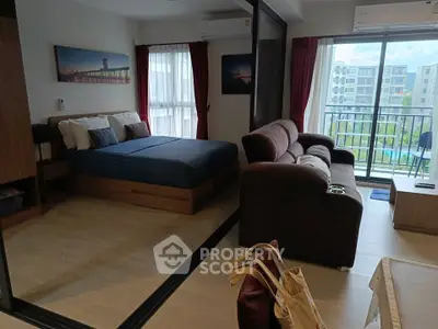 Modern studio apartment with cozy living area and balcony view