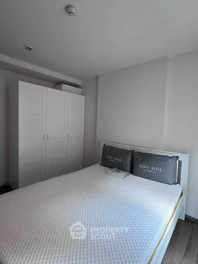 Modern bedroom with white wardrobe and comfortable bed in a stylish apartment.