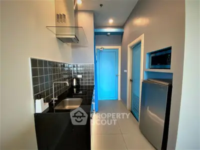 Modern compact kitchen with sleek black countertops and stainless steel appliances