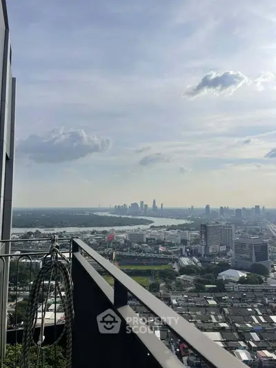 Stunning cityscape view from a high-rise balcony overlooking urban skyline and river.