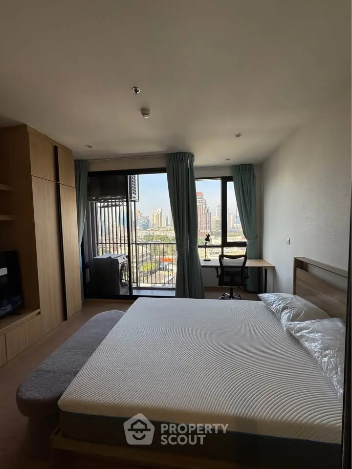 Spacious bedroom with city view and balcony access in modern apartment