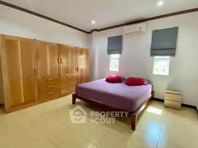 Spacious bedroom with wooden furniture and natural light