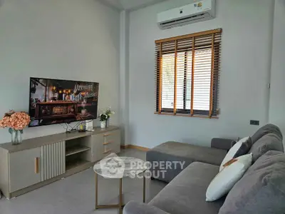 Modern living room with cozy sofa, stylish TV stand, and air conditioning.