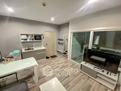 Modern living room with sleek furniture and open kitchen layout in stylish apartment.
