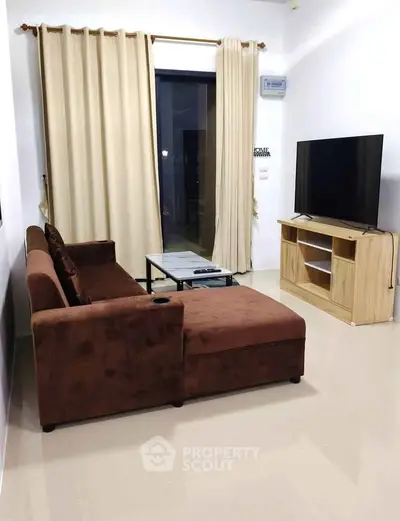 Modern living room with brown sectional sofa, flat-screen TV, and glass coffee table.