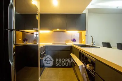 Modern kitchen with sleek black cabinets and integrated appliances