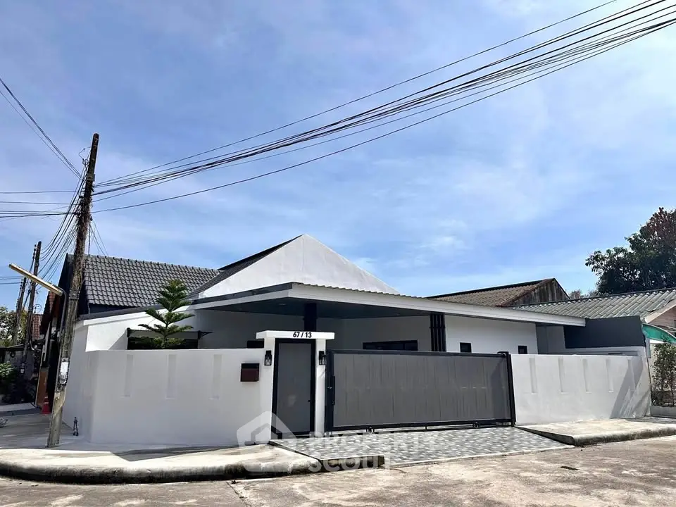 Modern single-story house with sleek design and gated entrance in a suburban neighborhood.