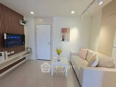 Modern living room with sleek design, cozy sofa, and wall-mounted TV, perfect for relaxation and entertainment.