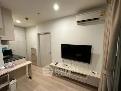 Modern living room with wall-mounted TV and air conditioning in a cozy apartment.