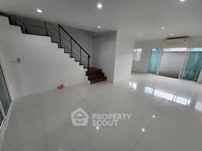 Spacious modern living room with sleek staircase and large windows