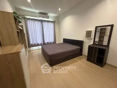 Spacious bedroom with modern furnishings and natural light