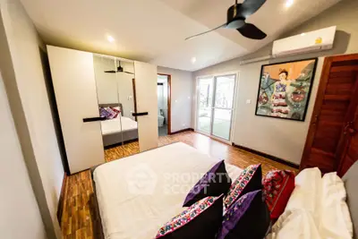 Spacious bedroom with modern decor and large mirrored wardrobe