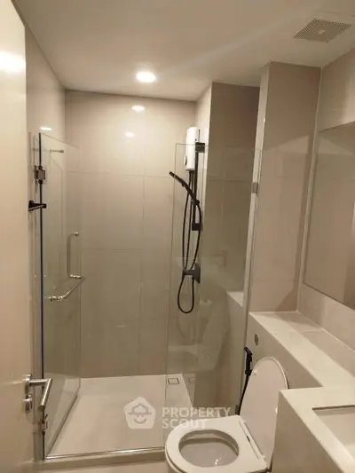 Modern bathroom with glass shower enclosure and sleek fixtures