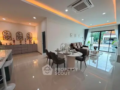 Spacious modern living room with elegant decor and large windows opening to a serene outdoor view.