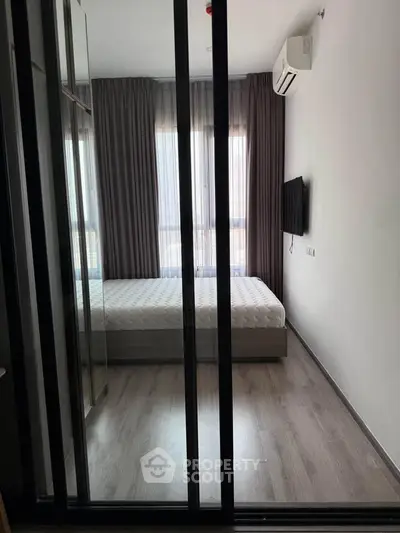 Modern bedroom with floor-to-ceiling windows and sleek furnishings