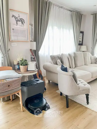 Elegant living room with plush sofa, stylish decor, and natural light streaming through large windows.