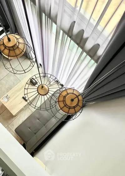 Modern loft-style living room with high ceilings and stylish pendant lights.
