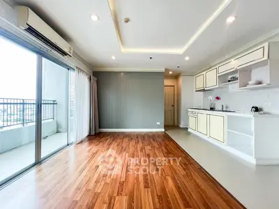Spacious open-plan living room with modern kitchen and balcony access.