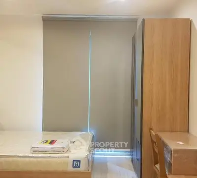 Cozy bedroom with modern furnishings and natural light filtering through blinds.