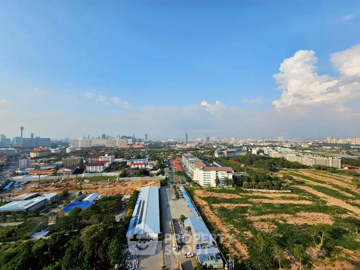Stunning panoramic cityscape view from high-rise building showcasing urban development and green spaces.