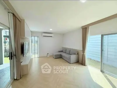 Spacious modern living room with large windows and sleek furniture