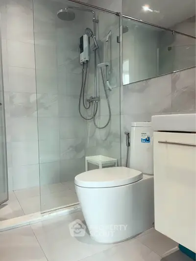 Modern bathroom with glass shower and sleek fixtures in a contemporary home.