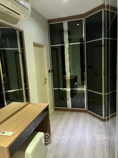 Modern bedroom with mirrored wardrobe and sleek wooden furniture